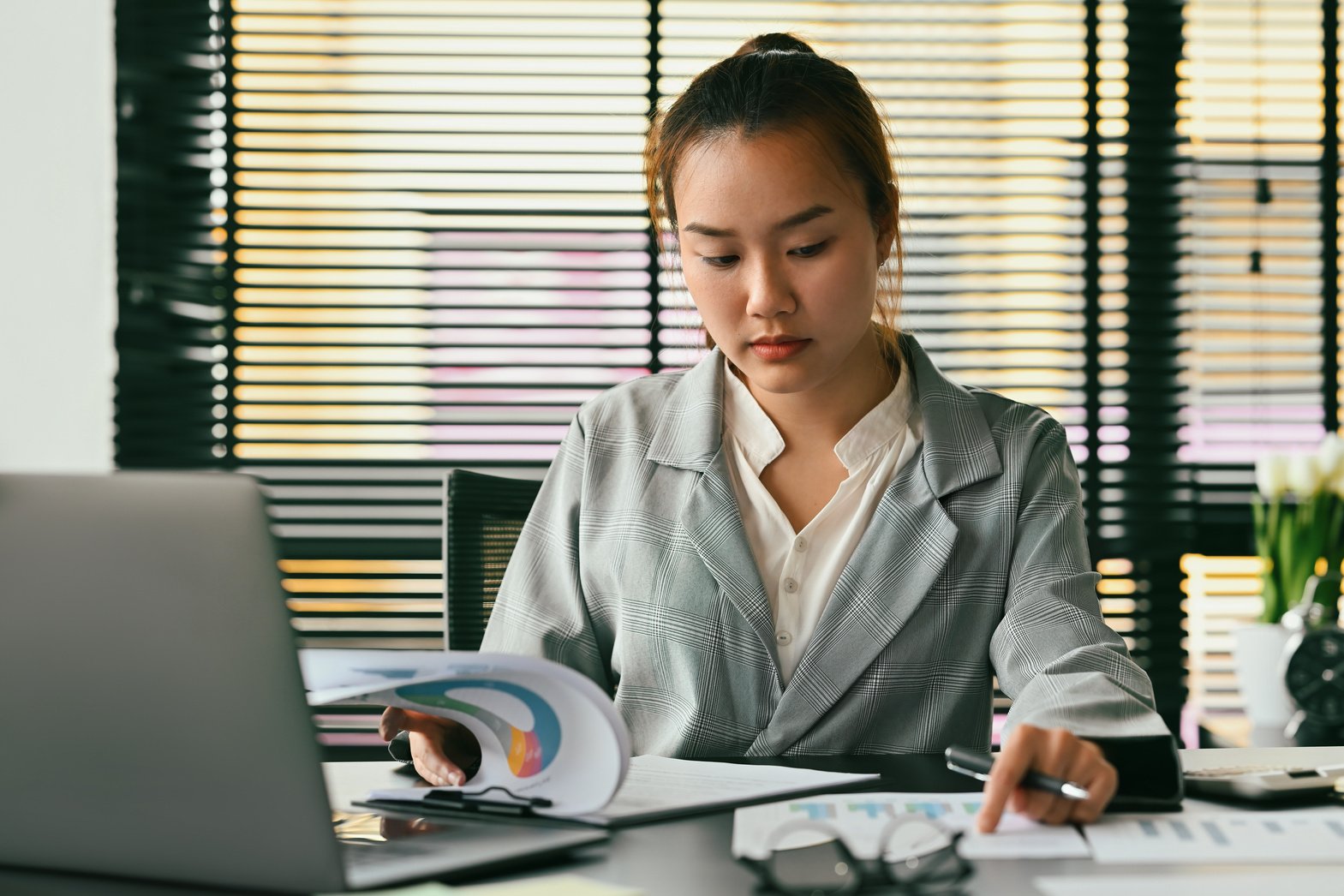 Chinese business woman working at office using a laptop and doin